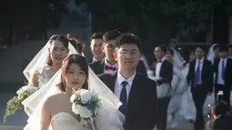 Beberapa pasangan pengantin bersiap untuk berfoto di Nanjing, Provinsi Jiangsu, China timur, (19/5/2020). Sebanyak 15 pasangan pengantin pada Selasa (19/5) berfoto bersama di Nanjing menjelang upacara pernikahan massal mereka yang dihelat pada 20 Mei. (Xinhua/Ji Chunpeng)