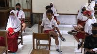 Sejumlah siswa menunggu antrean saat melakukan vaksinasi COVID-19 Pfizer di SDN Panunggangan 5, Pinang, Kota Tangerang, Selasa (19/10/2021).  Pelaksanaan vaksinasi untuk pelajar usia 12 tahun ini dilakukan dalam rangka persiapan pelaksanaan pembelajaran tatap muka (PTM). (Liputan6.com/Angga Yuniar)
