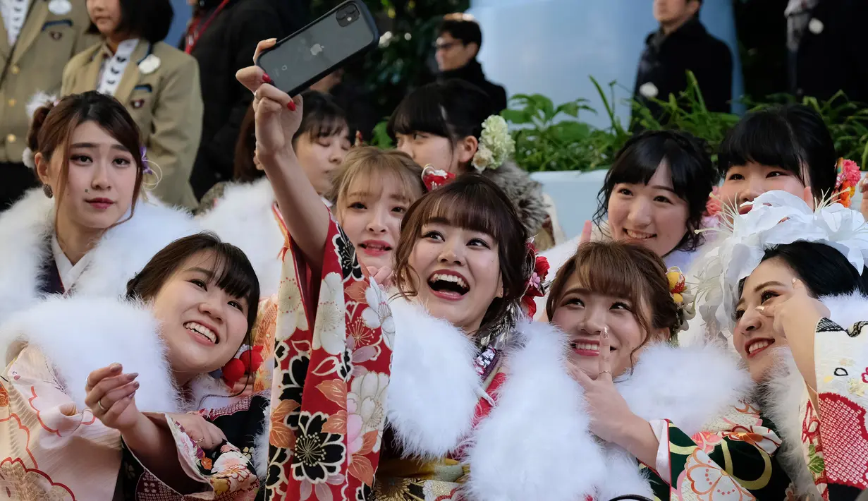 Sejumlah gadis Jepang mengenakan kimono berkumpul untuk upacara Coming of Age Day atau Hari Kedewasaan di Tokyo Disneyland, di Urayasu, Senin (13/1/2020). Coming of Age Day atau Hari Kedewasaan ini menandakan diperbolehkannya merokok, mengonsumsi alkohol dan mengikuti Pemilu. (Kazuhiro NOGI/AFP)