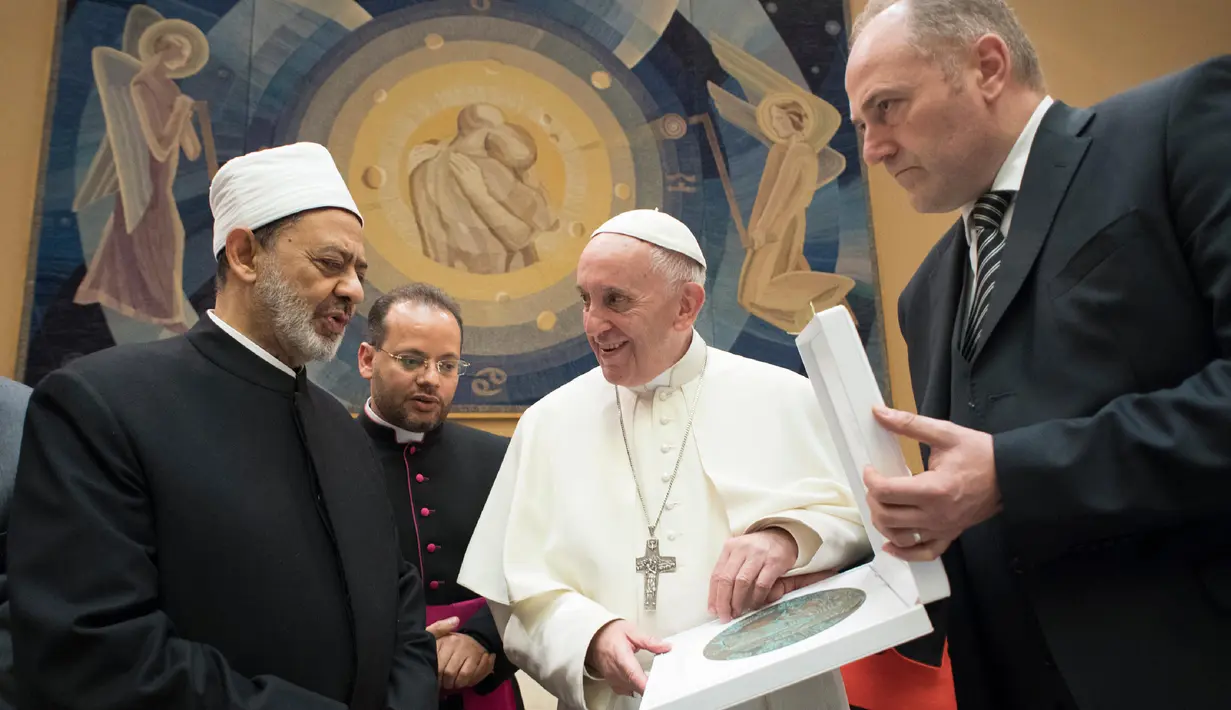 Pemimpin umat Katolik dunia, Paus Fransiskus dan Imam Besar Masjid Al-Azhar, Ahmed al-Tayeb bertukar hadiah pada sebuah pertemuan pribadi  di Vatikan, Selasa (7/11). (L'Osservatore Romano/Pool via AP)