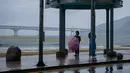 Seorang wanita berdiri dengan umbrealla di depan pantai Gwangalli di Busan (2/9/2020). Penerbangan dihentikan di Korea Selatan dan peringatan badai dikeluarkan di kedua sisi semenanjung Korea sebagai topan yang diperkirakan akan menjadi salah satu yang terkuat. (AFP/Ed Jones)
