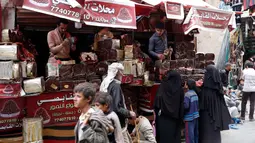 Pedagang kurma melayani pembeli selama bulan suci Ramadan di sebuah pasar di ibukota Sanaa, Yaman (22/5). (AFP Photo/Mohammed Huwais)