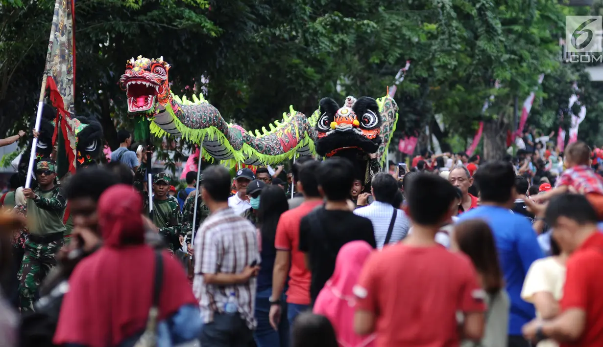 Atraksi liong menembus kerumunan warga di Jalan Gajah Mada, Jakarta, Minggu (4/3). Beragam atraksi budaya yang ada di Indonesia ditampilkan dalam karnaval perayaan Cap Go Meh 2018 di kawasan Glodok Jakarta. (Liputan6.com/Helmi Fithriansyah)