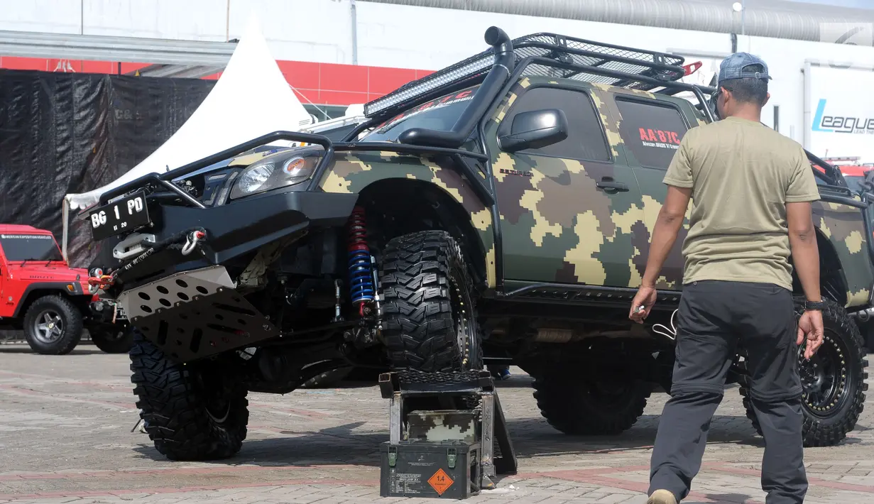 Peserta pameran mengecek kondisi kendaraan off road yang dipamerkan pada Indonesia International Motor Show 2018 di JIExpo, Jakarta, Jumat (20/4). IIMS 2018 diselenggarakan hingga 29 April mendatang. (Liputan6.com/Helmi Fithriansyah)