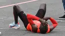 Pelari asal Kenya, Eliud Kipchoge terbaring di aspal setelah mencapai garis finis maraton di bawah 2 jam pada event Breaking2 di Sirkuit Monza, Italia, Sabtu (6/5). Eliud Kipchoge melahap 42.195 km dalam waktu 2 jam 0 menit 25 detik. (AP Photo/Luca Bruno)