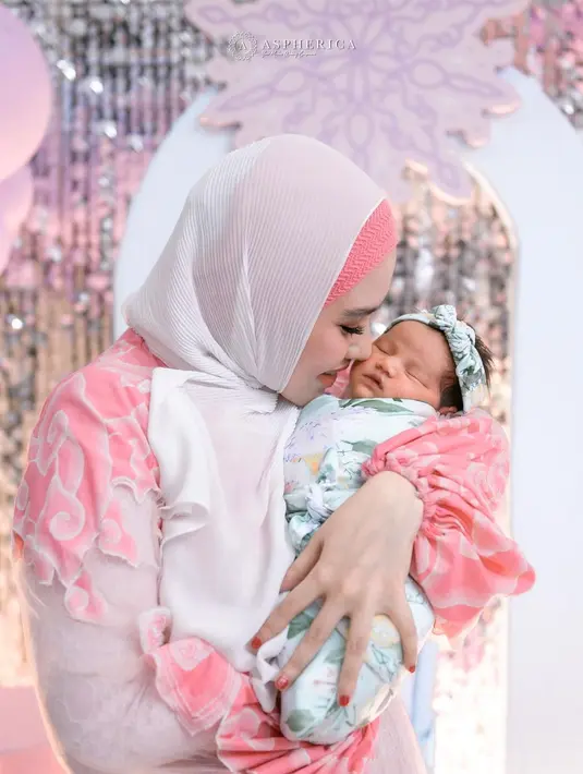 Sang bayi, Khadeeja terlihat lucu memakai bedong dan bandana berwarna hijau tosca. [Foto: instagram/kartikaputriworld]