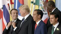 Joko Widodo diapit oleh Presiden AS Donald Trump dan Preside Meksiko Enrique Pena Nieto dalam sesi foto resmi KTT G20 (7/7/2017). (AP Photo/Jens Meyer)