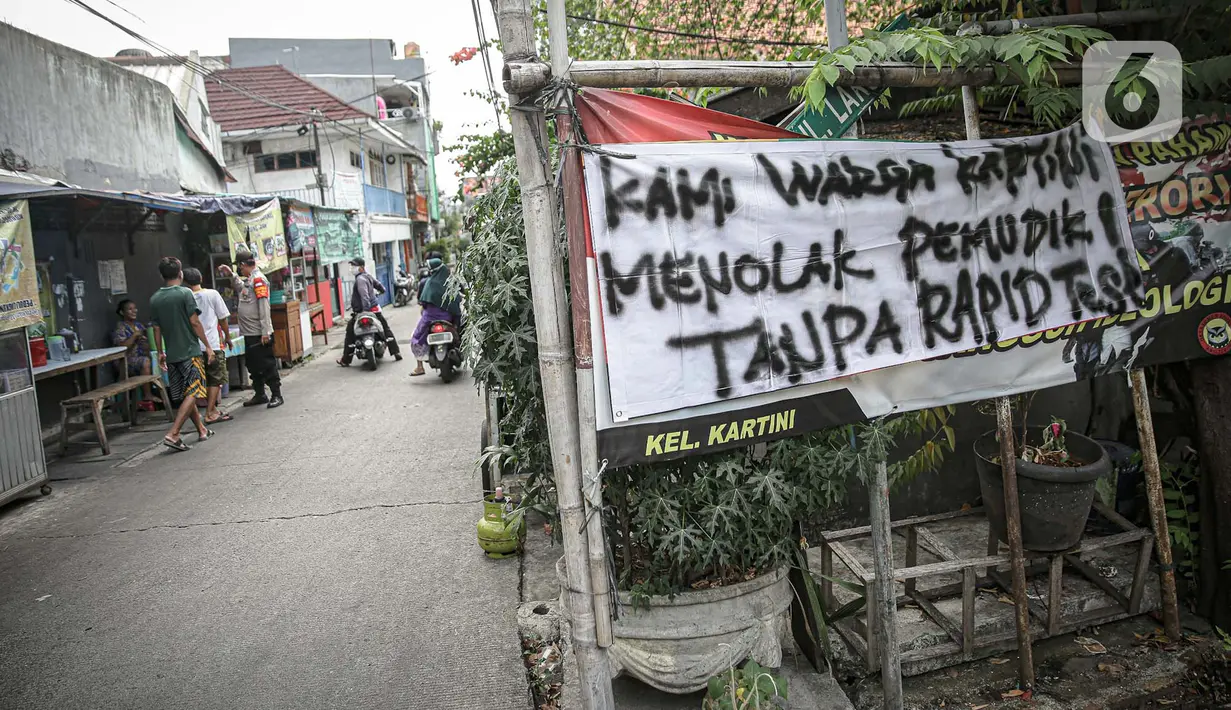 Sebuah spanduk peringatan untuk pemudik dipasang di kawasan Kartini, Sawah Besar, Jakarta, Senin (17/5/2021). Spanduk tersebut untuk memperingati warga yang kembali dari mudik lebaran agar membawa surat bebas COVID-19. (Liputan6.com/Faizal Fanani)