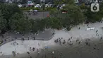 Pemandangan udara warga berlibur di Pantai Ancol, Pademangan, Jakarta Utara, Rabu (1/6/2022). Libur Nasional Hari Lahir Pancasila, dimanfaatkan warga mengajak sanak saudara tamasya di Pantai Ancol. (Liputan6.com/Herman Zakharia)