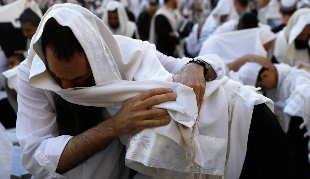Seorang umat Yahudi khusyuk berdoa Tembok Barat Kota Tua Yerusalem, Senin (2/4). Mereka memperingati eksodus besar-besaran bangsa Israel dari perbudakan di Mesir sekitar 3.500 tahun lalu. (MENAHEM KAHANA/AFP)