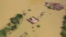 Warga bertahan di atap rumah yang terendam banjir sambil menunggu bantuan paket makanan yang didistribusikan oleh helikopter Angkatan Udara India di pinggiran Allahabad, India, Kamis (25/08). (REUTERS / Jitendra Prakash)