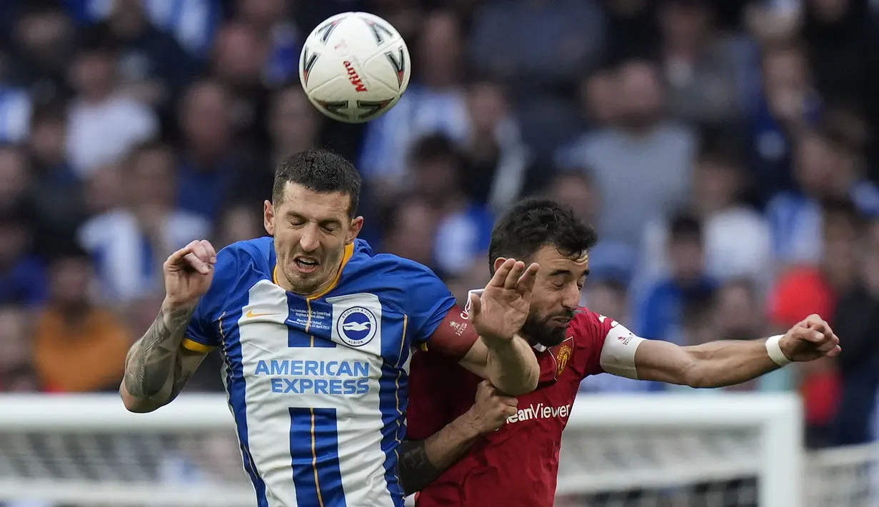Pemain Manchester United, Bruno Fernandes (kanan) berebut bola dengan pemain Brighton, Lewis Dunk saat laga semifinal Piala FA 2022/2023 di Stadion Wembley, London, Minggu (23/04/2023). MU menang dengan skor 7-6 pada babak adu penalti. (AP Photo/Alastair Grant)