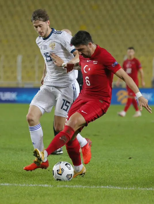 Gelandang Turki, Ozan Tufan membawa bola dari kawalan pemain Rusia, Kaan Kayhan pada pertandingan UEFA Nations League di Stadion Sukru Saracoglu, Istanbul, Minggu (15/11/2020). Turki menang tipis atas Rusia 3-2. (AP Photo)