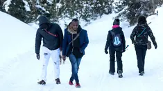 Dua imigran dari Pantai Gading berjalan menuju Colle della Scala (Col de l'Echelle) sebuah jalan yang tertutup salju, untuk melintasi perbatasan antara Italia dan Prancis di Pegunungan Alpen, Italia (13/1). (AFP/Piero Cruciatti)