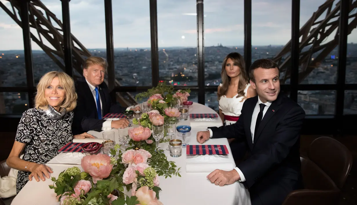 Presiden AS Donald Trump dan Melania Trump bersama Presiden Prancis Emmanuel Macron dan Brigitte Macron dalam jamuan makan malam di Menara Eifel, Paris, Kamis (13/7). Di sana, mereka menikmati pemandangan Paris yang indah dan romantis. (AP/Carolyn Kaster)