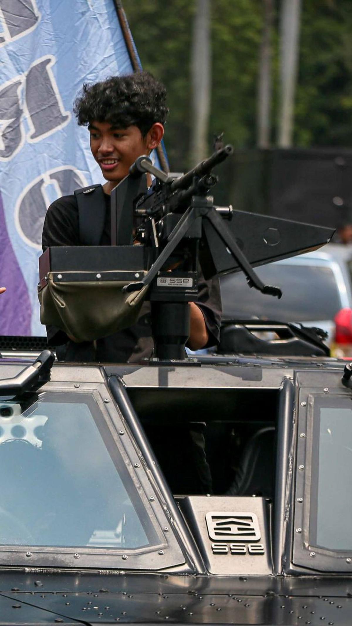 Salah seorang warga mencoba duduk di depan senjata rantis saat berfoto di atas kendaraan milik TNI saat pameran Alutsista di kawasan Monas, Jakarta, Minggu (24/9/2023).
