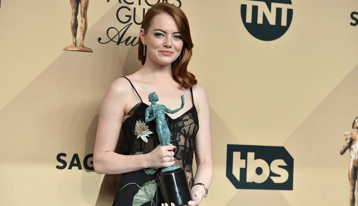 Gaun hitam yang melekat ditubuh Emma Stone merupakan rancangan Alexander McQueen. Pemeran wanita utama film Lalala Land ini seperti memakai lingerie di dalam gaun semi-transparan yang berhias aksen bunga lily.  (Jordan Strauss/Invision/AP)
