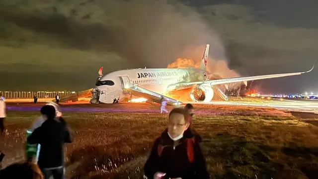 Potret penampakan penumpang Japan Airlines (JAL) lari menyelamatkan diri dari kebakaran pesawat di bandara Haneda, Tokyo, Jepang.