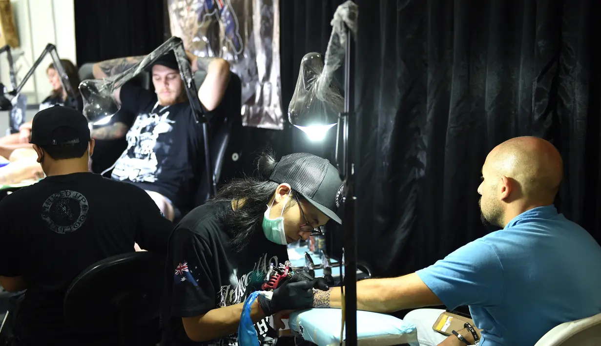 Sejumlah pengunjung saat membuat tato di Bali Tattoo Expoo 2017 di pulau resor Indonesia, Denpasar, Bali (12/5). Acara ini digelar selama 3 hari, mulai (12/5/2017) sampai (14/5/2017). (AFP Photo/Sonny Tumbelaka)