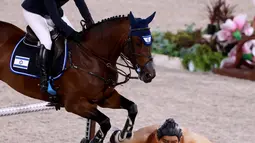 Atlet Israel Ashlee Bond menunggangi Donatello 141 melompati patung sumo (kanan) di final lompat individu berkuda selama Olimpiade Tokyo 2020 di Equestrian Park di Tokyo (4/8/2021). Beberapa atlet berkuda mengaku, kalau kuda mereka ketakutan karena adanya patung pesumo tersebut. (AFP/Behrouz Mehri)