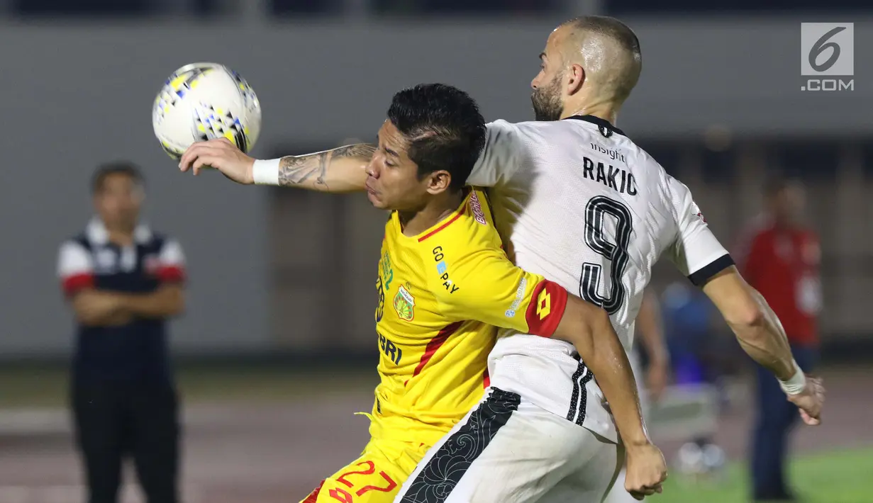 Pemain depan Madura United FC, Aleksander Rakic (kanan) berebut bola dengan bek Bhayangkara FC, Indra Kahfi pada lanjutan Shopee Liga 1 Indonesia 2019 di Stadion Madya Gelora Bung Karno, Jakarta, Senin (5/8/2019). Laga kedua tim berakhir imbang 1-1. (Liputan6.com/Helmi Fithriansyah)