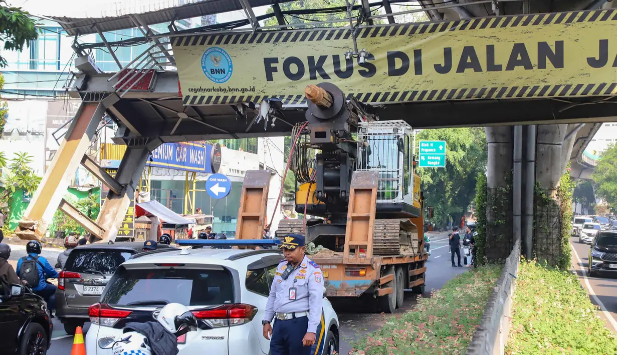 Sebuah truk  truk towing pengangkut alat berat (crane)  tersangkut dan merusak  jembatan penyeberangan orang (JPO) di Jalan Raya Kapten Tendean, Jakarta, Selasa (14/07/2026).