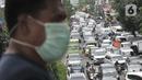 Warga melintasi JPO saat kemacetan terjadi di depan Pasar Pramuka, Jakarta, Senin (16/3/2020). Pasar Pramuka diserbu pembeli yang mencari masker guna mengantisipasi virus Corona, membuat sebagian badan jalan dimanfaatkan sebagai parkiran sehingga menyebabkan kemacetan. (merdeka.com/Iqbal Nugroho)