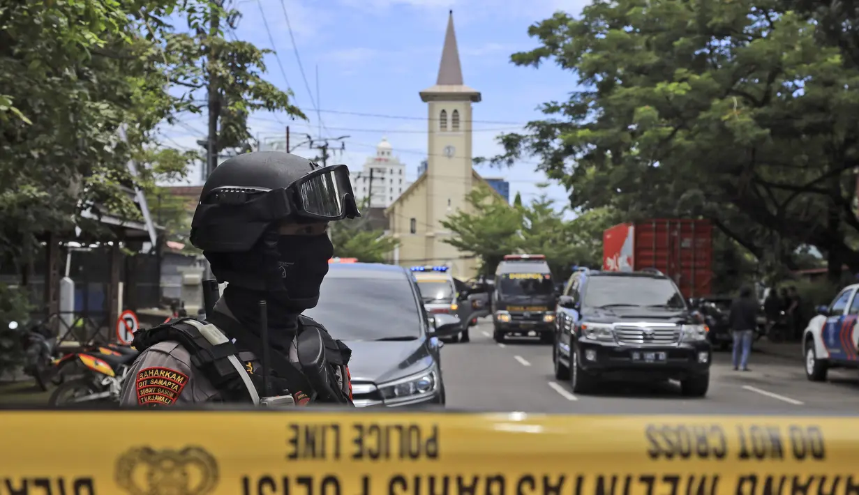 Petugas polisi berjaga di dekat gereja tempat ledakan meledak di Makassar, Sulawesi Selatan, Minggu (28/3/2021). Pastor Gereja Katedral Makassar, Wilhelminus Tulak menyampaikan ledakan terdengar sangat keras. Bahkan, kaca-kaca hotel di samping gereja turut terkena dampak. (AP Photo/Yusuf Wahil)