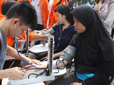 Warga mengecek darah saat car free day (CFD) di Jakarta,Minggu (13/1). Sejumlah mahasiswa dari universitas di Jakarta menggelar pengecekan darah bagi warga yang berolahraga saat CFD. (Liputan6.com/Angga Yuniar)