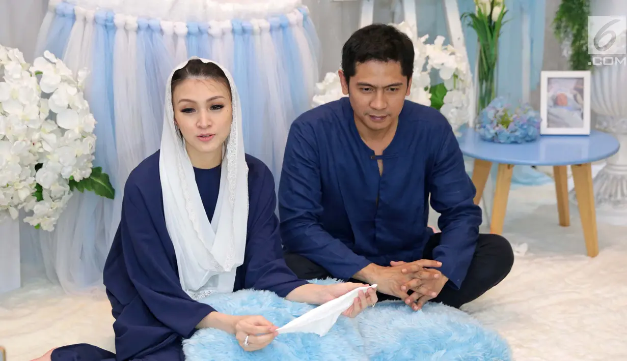 Pasangan selebritis Adi Nugroho dan Donita menjawab pertanyaan wartawan usai prosesi aqiqah anak kedua mereka, Parvaiz Farezell Shaquill Nugroho di Kebayoran View, Tangerang Selatan, Kamis (18/1). (Liputan6.com/Herman Zakharia)