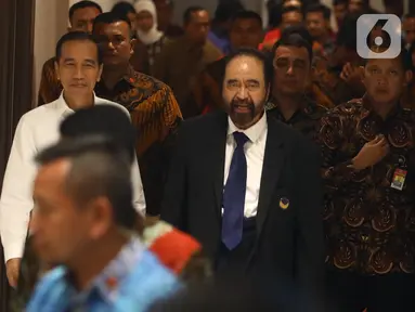 Presiden Joko Widodo atau Jokowi (kiri) didampingi Ketua Umum Partai Nasdem Surya Paloh (kanan) saat menghadiri perayaan ulang tahun ke-8 Partai Nasdem di JIExpo, Jakarta, Senin (11/11/2019). Surya Paloh menyambut langsung kedatangan Jokowi di HUT Nasdem. (Liputan6.com/Angga Yuniar)