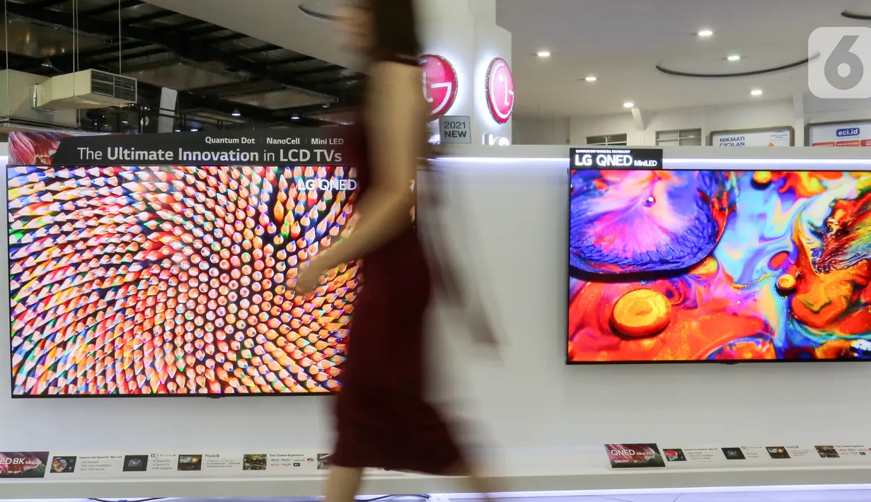 Model melintas di depan dua LG QNED Mini LED TV di toko elektronik SCBD, Jakarta, Sabtu (25/09/2021). PT LG Electronics Indonesia (LG) resmi mengumumkan TV premium, LG QNED Mini LED TV yang dikembangkan dua teknologi pada  LCD TV yaitu Quantum Dot NanoCell dan Mini LED. (Liputan6.com)