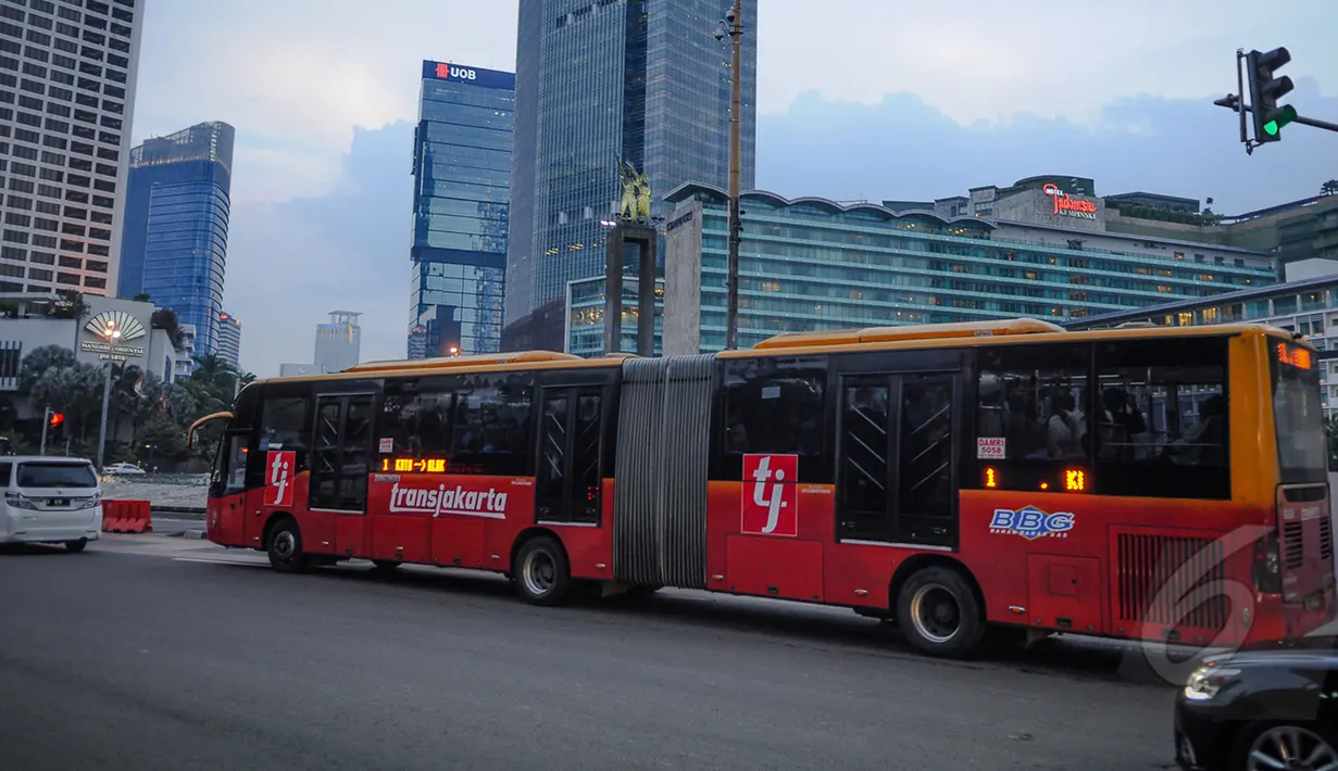 Bus TransJakarta melewati kawasan Bundaran HI, Jakarta, Senin (9/3/2015). PT Transjakarta menghentikan operasional 30 bus merek Zhongtong pasca insiden terbakarnya bus buatan Tiongkok itu pada Minggu (8/3) kemarin. (Liputan6.com/Faizal Fanani)