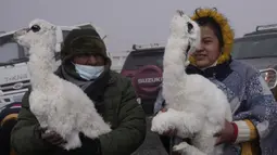 Seorang pria dan wanita memegang llama muda untuk dibakar dalam ritual persembahan menghormati Pachamama atau Ibu Pertiwi di pinggiran La Paz, Bolivia, Minggu (1/8/2021). Menurut tradisi Aymara, Pachamama terbangun lapar dan haus setiap bulan Agustus setelah musim kemarau. (AP Photo/Juan Karita)