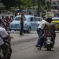 Seorang polisi mengatur lalu lintas di persimpangan dengan lampu lalu lintas padam karena pemadaman listrik terprogram di Regla, Kuba, Senin, 1 Agustus 2022. Pihak berwenang telah mengumumkan akan memulai pemadaman listrik terjadwal mulai awal Agustus. (AP Photo/Ramon Espinosa)