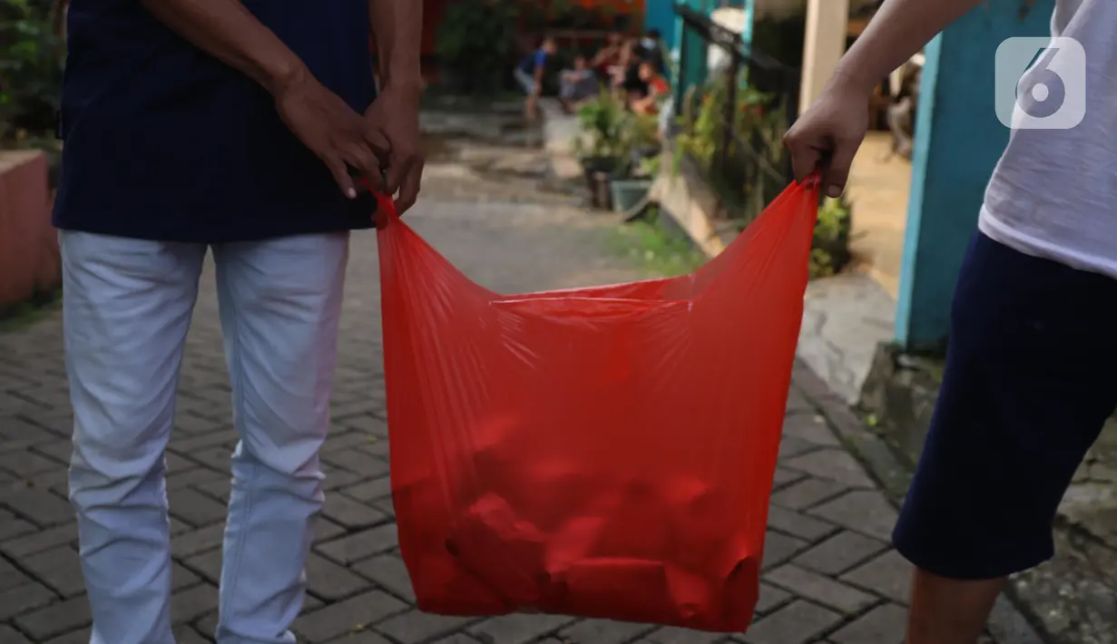 Warga membawa nasi bungkus untuk warga yang terdampak Covid-19 di di RW 03, Kelurahan Gandasari, Kecamatan Jatiuwung, Kota Tangerang, Jumat (11/6/2021).  Dampak penerepan lockdown membuat warga sekitar yang sehat melakukan aksi bersama untuk menyuplai makanan.  (Liputan6.com/Angga Yuniar)