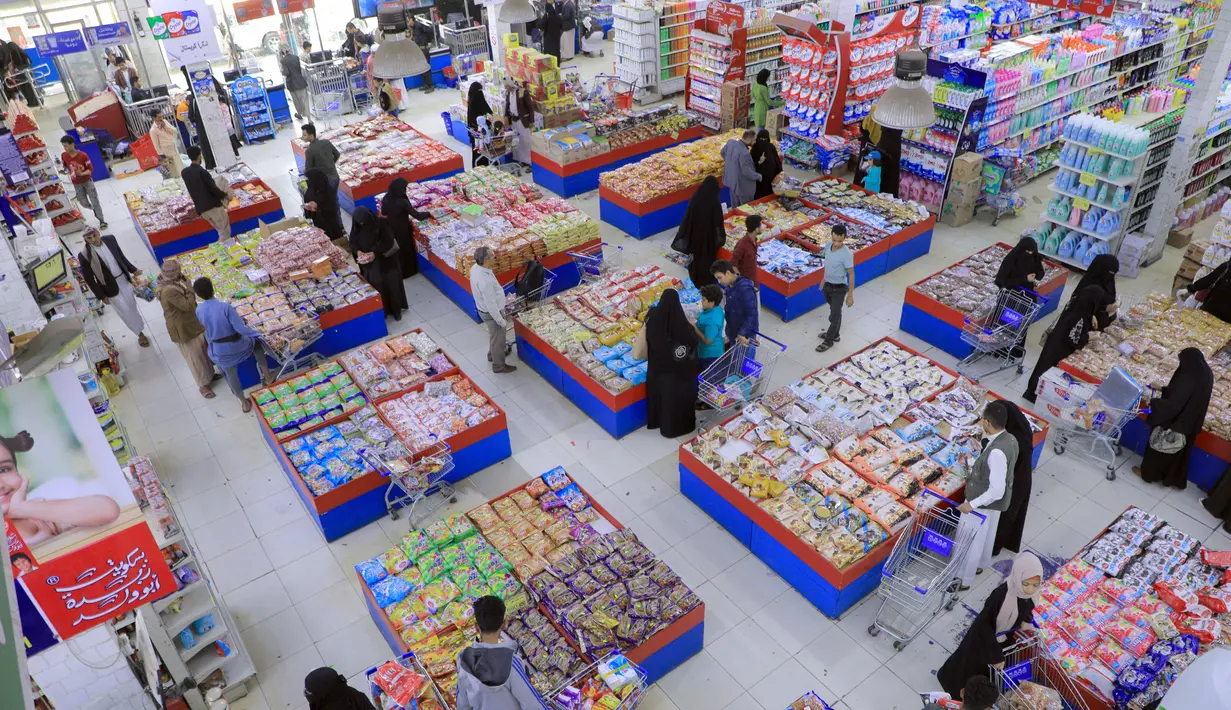 Warga Yaman membeli permen dan kacang-kacangan saat umat Islam bersiap untuk merayakan liburan tahunan Idul Adha (Hari Raya Kurban) di supermarket di ibu kota Sanaa (18/7/2021). (AFP/Mohammed Huwais)