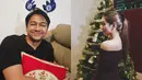 Rayakan Natal perdana sebagai pasutri, Mikha Tambayong tampil manis dengan dress sabrina warna merah maroon, sementara Deva mengenakan atasan hitam dan bandana Natal warna biru. [@miktambayong]