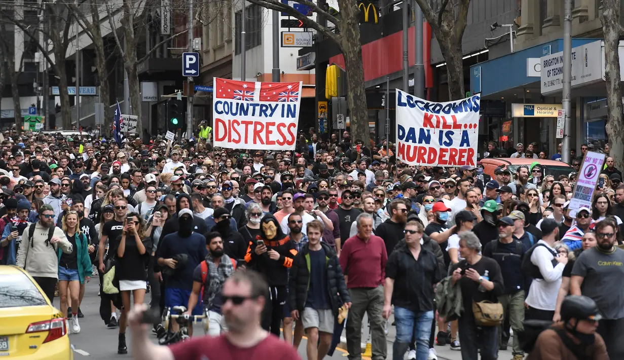 Para pengunjuk rasa berbaris di jalan-jalan selama rapat umum anti-lockdown di tengah penguncian keenam kota untuk menahan wabah virus corona di Melbourne (21/8/2021). (AFP/William West)