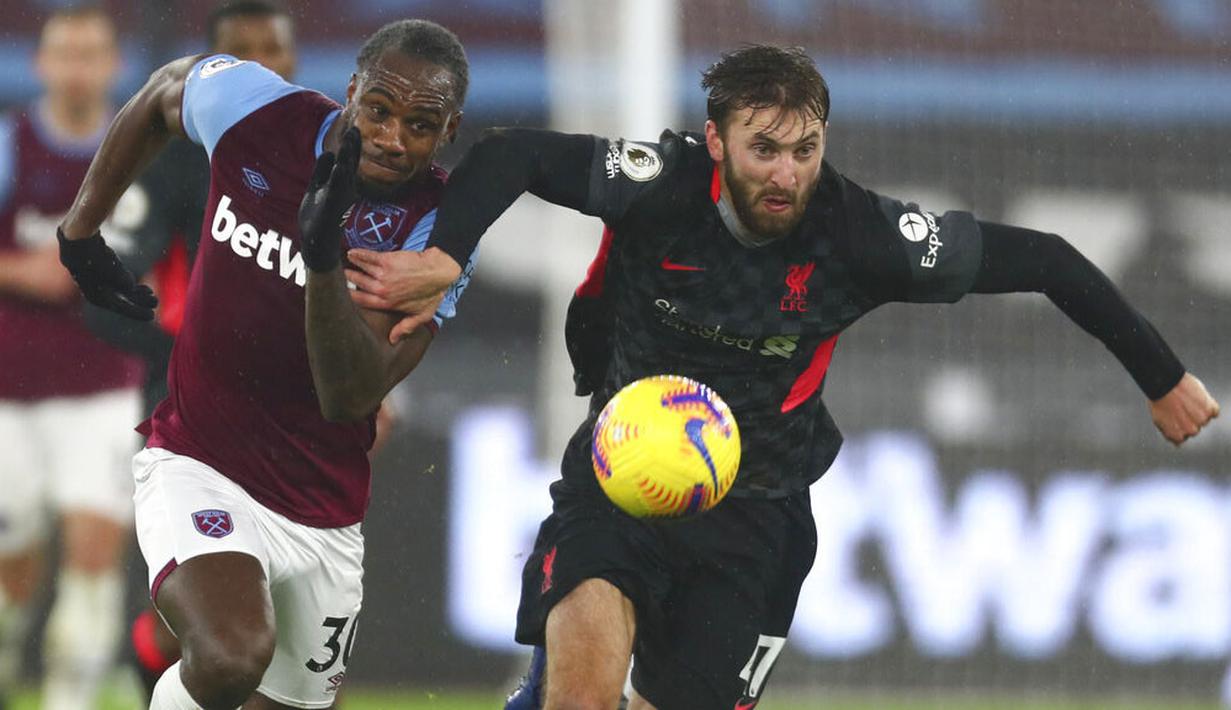 Pemain Liverpool, Nathaniel Phillips, berebut bola dengan pemain West Ham United, Michail Antonio, pada laga Liga Inggris di Stadion London, Minggu (31/1/2021). Liverpool menang dengan skor 3-1. (Clive Rose/Pool via AP)
