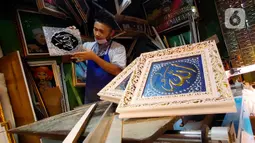 Pengrajin tengah mebuat bingkai untuk lukisan kaligrafi di Tangerang, Rabu (6/5/2020). Akibat Covid-19 yang tengah mewabah membuat para pengrajin tersebut terimbas akibat sepinya peminta lukisan kaligrafi pada bulan ramadan tahun ini. (Liputan6.com/Angga Yuniar)