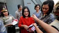 Iriana Jokowi membagikan buku kepada warga di Lapangan Bedeng, Pisangan Baru, Jakarta, Selasa (8/9/2015). Kedatangan Presiden Jokowi untuk memberikan sejumlah paket sembako. (Liputan6.com/Helmi Fithriansyah)