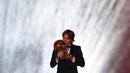 Gelandang Real Madrid asal Kroasia, Luka Modric, mencium trofi saat malam penghargaan Ballon d'Or di Paris, Senin (3/12). Dirinya berhasil meraih gelar Ballon d'Or. (AFP/Franck Fife)