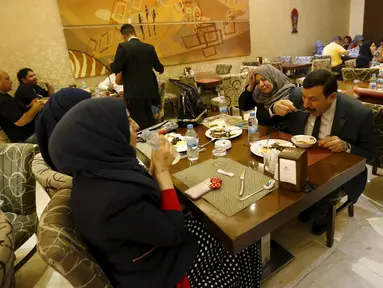 Sejumlah kafe di Irak mulai ramai dikunjungi saat waktu sahur oleh sejumlah warga, Irak, Kamis (9/7/2015). Setelah hampir 10 tahun tak boleh keluar malam, kini warga Irak bisa sahur bersama di Kafe. (Reuters Thaier Al-Sudani)