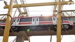 Proses perdana gerbong kereta layang ringan atau light rail transit (LRT) ke lintasan rel di Stasiun Harjamukti, Cibubur, Minggu (13/10/2019). Sebanyak satu rangkaian (trainset) yang terdiri dari 6 kereta (car) diangkat ke atas rel menggunakan Gantry Crane. (merdeka.com/Iqbal S Nugroho)