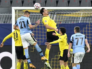 Bek Borussia Dortmund, Mats Hummels (kanan atas) menyundul bola melewati gelandang Lazio, Milinkovic-Savic pada matchday kelima Grup F Liga Champions di Signal Iduna Park, Dortmund, Kamis (3/12/2020) dinihari WIB. Borussia Dortmund cuma berimbang 1-1 dengan Lazio. (AP Photo/Martin Meissner, Pool)