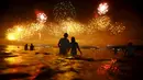 Sejumlah orang saat menyaksikan kembang api di pantai Copacabana saat perayaan Tahun Baru 2016 di Rio de Janeiro, Brasil, (1/1/2016). (REUTERS/Ricardo Moraes)