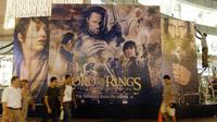 Orang berjalan di depan poster film The Lord of the Rings di sebuah bioskop di Singapura (3/12/2003). (AFP/Roslan Rahman)