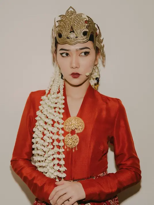 Kebaya tersebut dipadukan dengan kain batik nuansa merah-emas, bros, dan siger sunda dari Subeng Klasik. [Instagram/isyanasarasvati]