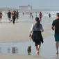 Warga berjalan di pantai selama pandemi Covid-19 di Jacksonville Beach, Florida (17/4/2020). Gubernur Ron DeSantis memberikan lampu hijau beberapa pantai dan taman untuk dibuka kembali jika dapat dilakukan dengan aman setelah ditutup karena Covid-19.  (Will Dickey/The Florida Times-Union via AP)